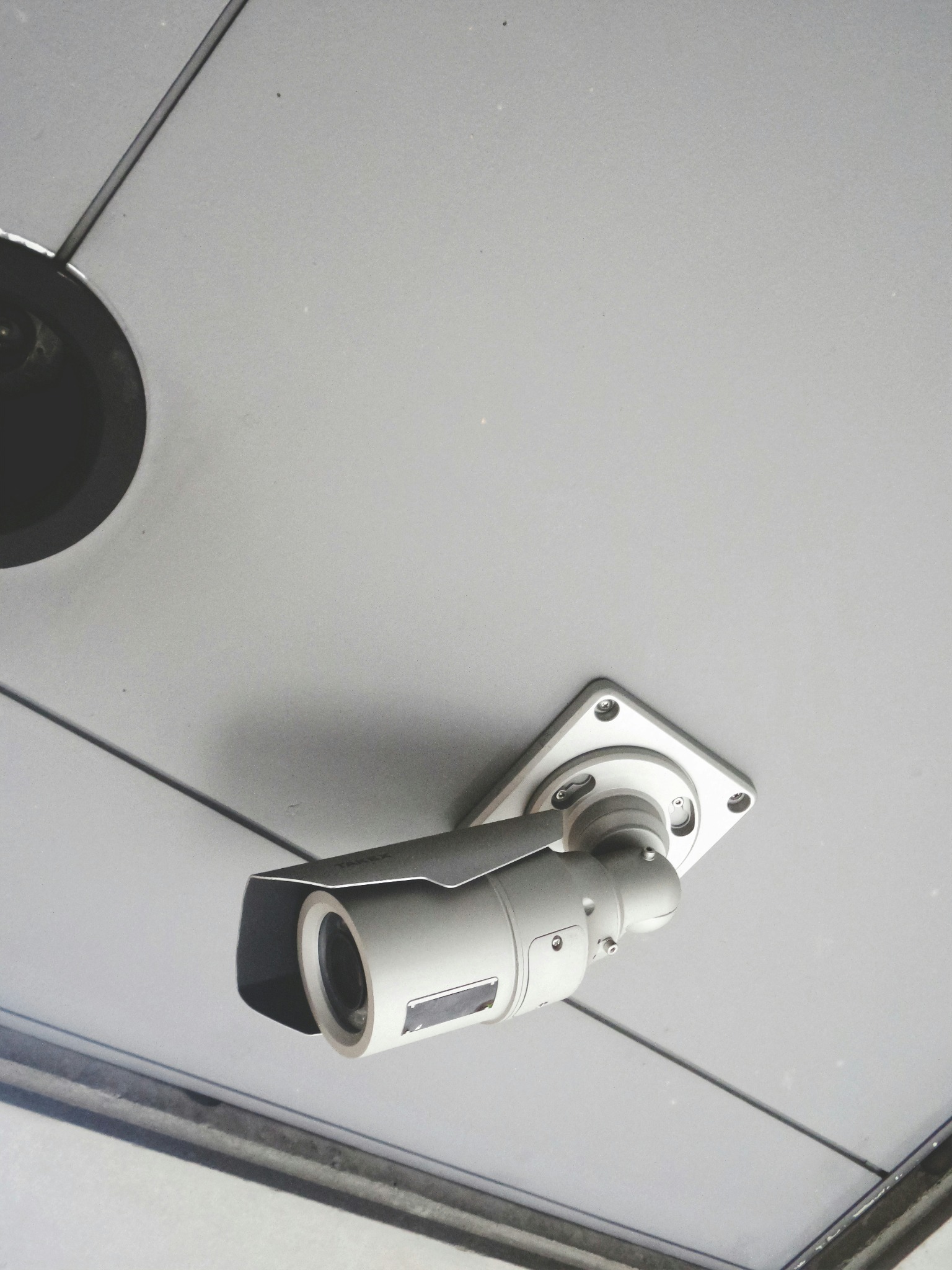 White security camera mounted on a ceiling